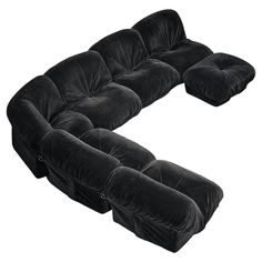 a large black couch sitting on top of a white floor