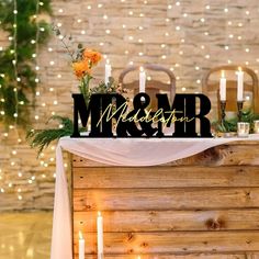 a wooden table topped with candles and a sign that says mr and mrs on it