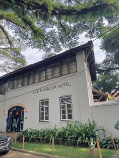 the old harbour hotel is located on the corner of an intersection with cars parked in front