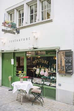 the outside of a restaurant with tables and chairs