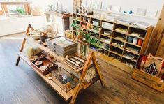 a room filled with lots of wooden shelves and books on top of each other in front of a window