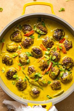 a pan filled with meatballs covered in yellow sauce