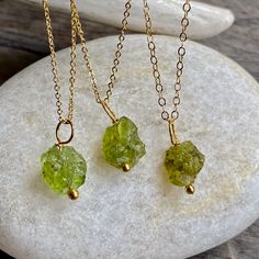 Beautiful and all-natural peridot gemstones hung from a dainty an light-catching gold fill chain. Peridot symbolizes strength. It was once believed that the green peridot crystals found in volcanic ashes were the tears of the volcano goddess, Pele. When set in gold, this gem was said to protect the wearer from nightmares. Peridots are the birthstone for August and also traditionally given on the 16th wedding anniversary. ★Chain- High quality 14k gold fill in your choice of length ★Stone-Untreate Green Peridot Necklace For May Birthstone, Green Spiritual Necklace With Birthstone, Dainty Gold Necklace With Raw Stone, Peridot Gemstone Necklace For May Birthstone, Lime Green Peridot Necklace For May Birthstone, Dainty Green Gemstone Charm Necklace, Healing Green Raw Stone Jewelry, Peridot Jewelry With Natural Stones For Healing, Peridot Birthstone Necklace For May