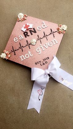 a pink graduation cap with flowers on it and a ribbon tied around the top that says, eaarne's heartbeat not given