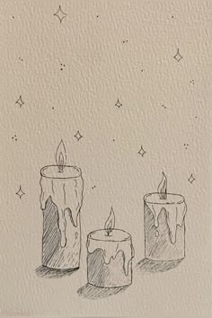 three lit candles sitting next to each other on top of a piece of white paper