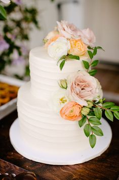 a white wedding cake with flowers on top