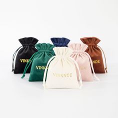 six small velvet bags with the words vinnkue printed on them, all lined up in different colors