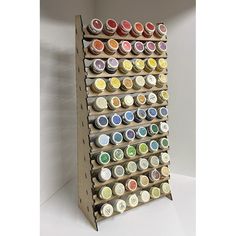 a wooden display case filled with lots of different colored paint cups and sauces on it's sides