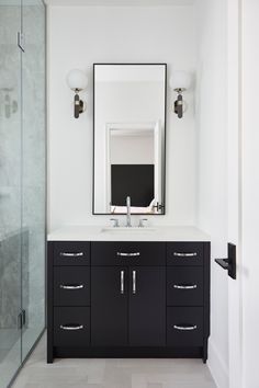 a black and white bathroom with a large mirror