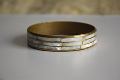 Vintage gold brass bangle inlaid with mother of pearl pieces, in shiny shades of white. Era - 80s / 90s Handmade in India, has some imperfections, see photos Diameter (on inside) - 2.55 inches / 6.5 cm Height - 0.6 inches / 1.5 cm Condition: Good vintage condition with normal signs of wear like discoloration and patina! Festival Armband, Bracelets Hippie, Festival Bracelets, Hippie Bracelet, Boho Bangle, Bracelet Stacking, Brass Bangle, Hippie Bracelets, Brass Bracelet