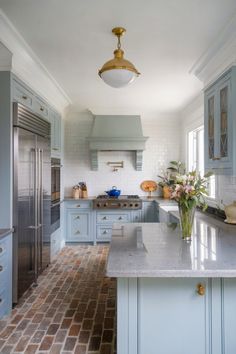 a large kitchen with blue cabinets and white counter tops, an island in the middle