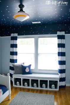 a child's bedroom with stars painted on the ceiling and window seat in the corner