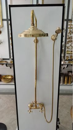 an antique shower head and handset with gold fixtures in a store display case,