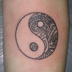 a black and white image of a yin - yang tattoo on the right arm,