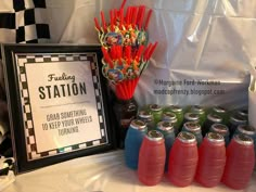 there are many sodas and drinks on the table with a sign that says station