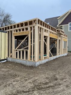 a house being built in the middle of a yard with lots of wood on it