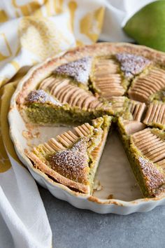 a pie with several slices cut out and sitting on a plate next to an apple