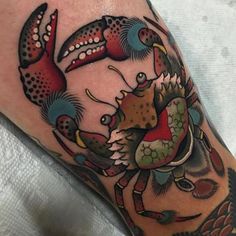 a close up of a person's leg with a crab tattoo on the arm