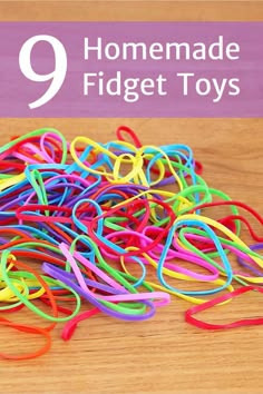 a pile of multicolored rubber bands sitting on top of a wooden table