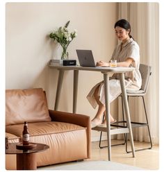 a woman sitting at a table using a laptop computer