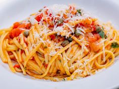 a plate of pasta with tomato sauce and parmesan cheese