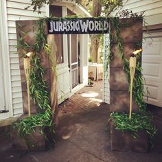 an entrance to a house decorated with greenery and candles in the shape of flowers