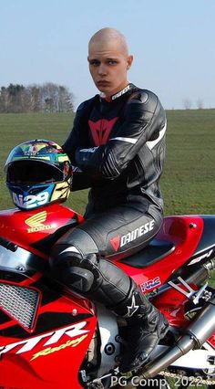 a man sitting on top of a red motorcycle