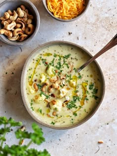 three bowls filled with different types of food on top of a white countertop next to some parmesan cheese