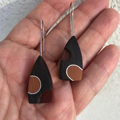 These mismatched wooden earrings are hand fabricated  from sterling silver and padouk,ebony,okoume woods. These asymmetrical  earrings will be a great 5th anniversary gift for her or a lovely gift for nature lovers. - These unusual wood earrings are made of  woods and sterling silver. They are the natural color of the woods. There is no paint on these mismatched wooden earrings.   - The length of asymmetrical wood earring is approx. 2 inches (5 cm) - The weight of each unusual wooden earring is approx. 0.07 ounce (1,9 g)   - You'll get the wooden jewelry in a little box ready to give away and also you can add a gift message during purchase - No CNC or similar tools have been used, each earrings are handmade. Please note since it's a handmade wood silver earrings, there can be slight variat Asymmetrical Earrings, Unusual Earrings, Wooden Earrings, Anniversary Gift For Her, Wood Earrings, Gifts For Nature Lovers, Wooden Jewelry, Lovely Gift, Silver Earrings