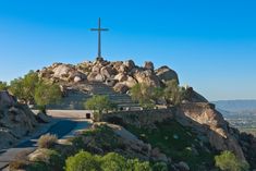 a cross on top of a hill with rocks