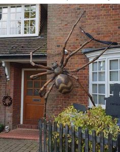 a large spider statue in front of a house