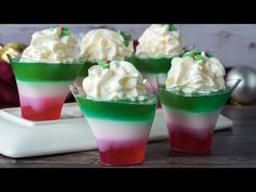 four dessert cups with whipped cream and candy on top