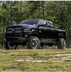 a black ram truck parked in the woods