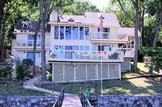 a large house with flags on the front and second story above it's porch