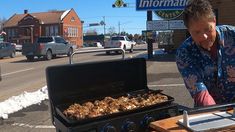 a man cooking food on top of an outdoor grill