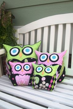 three decorative owls are sitting on a bench