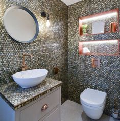 a bathroom with a sink, toilet and mirror on the wall next to each other