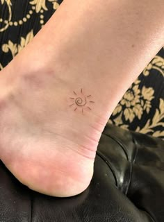 a person with a small sun tattoo on their foot