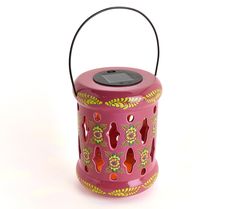 a pink lantern with an intricate design on the front and sides, sitting on a white surface