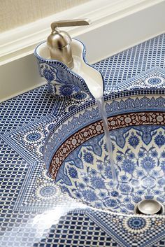 a blue and white sink with a faucet running from the faucet