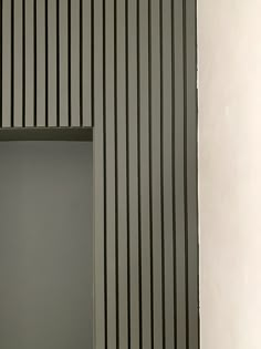 a white toilet sitting in a bathroom next to a wall with vertical lines on it