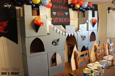 a castle made out of cardboard with balloons on the ceiling and decorations around it for halloween