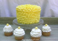 there are cupcakes with yellow frosting on the cake plate and four other cupcakes next to it