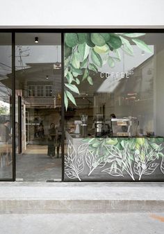 the front window of a coffee shop with people walking by