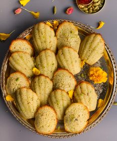 a platter filled with cookies on top of a table next to dried yellow flowers