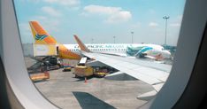 an airplane is parked on the tarmac with another plane in the background as seen from inside