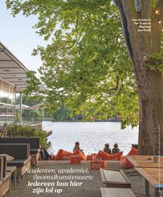 the cover of an outdoor magazine with people sitting at picnic tables and looking out over water