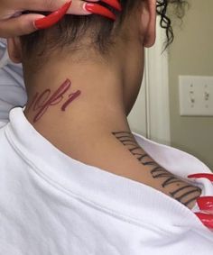 a woman with red nail polish on her neck and behind her ear is a tattoo