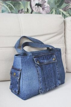 a denim purse sitting on top of a couch