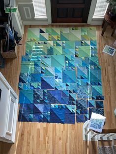 an aerial view of a living room with wood floors and blue quilts on the floor